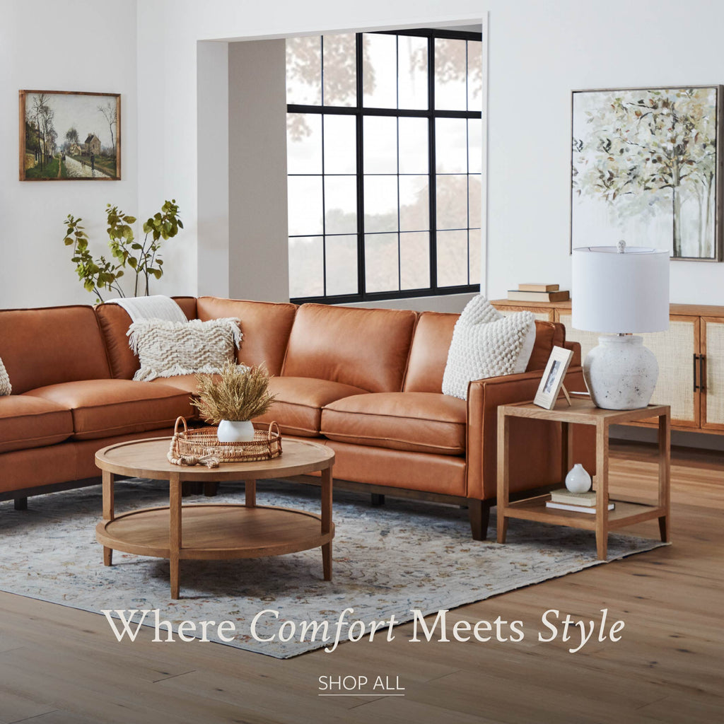 Living room scene with tan leather sectional, area rug, coffee table and end table.