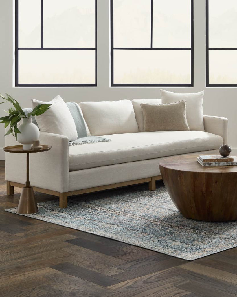 White sofa with coffee table and end table.
